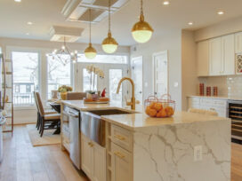 A beautiful light colored themed kitchen with shelves, cabinets and workstation