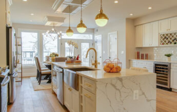 A beautiful light colored themed kitchen with shelves, cabinets and workstation