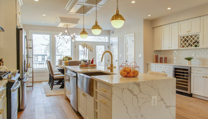 A beautiful light colored themed kitchen with shelves, cabinets and workstation