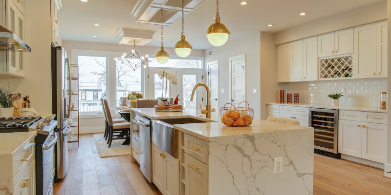 A beautiful light colored themed kitchen with shelves, cabinets and workstation